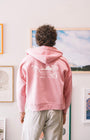 Man with a pink sweater with art wall