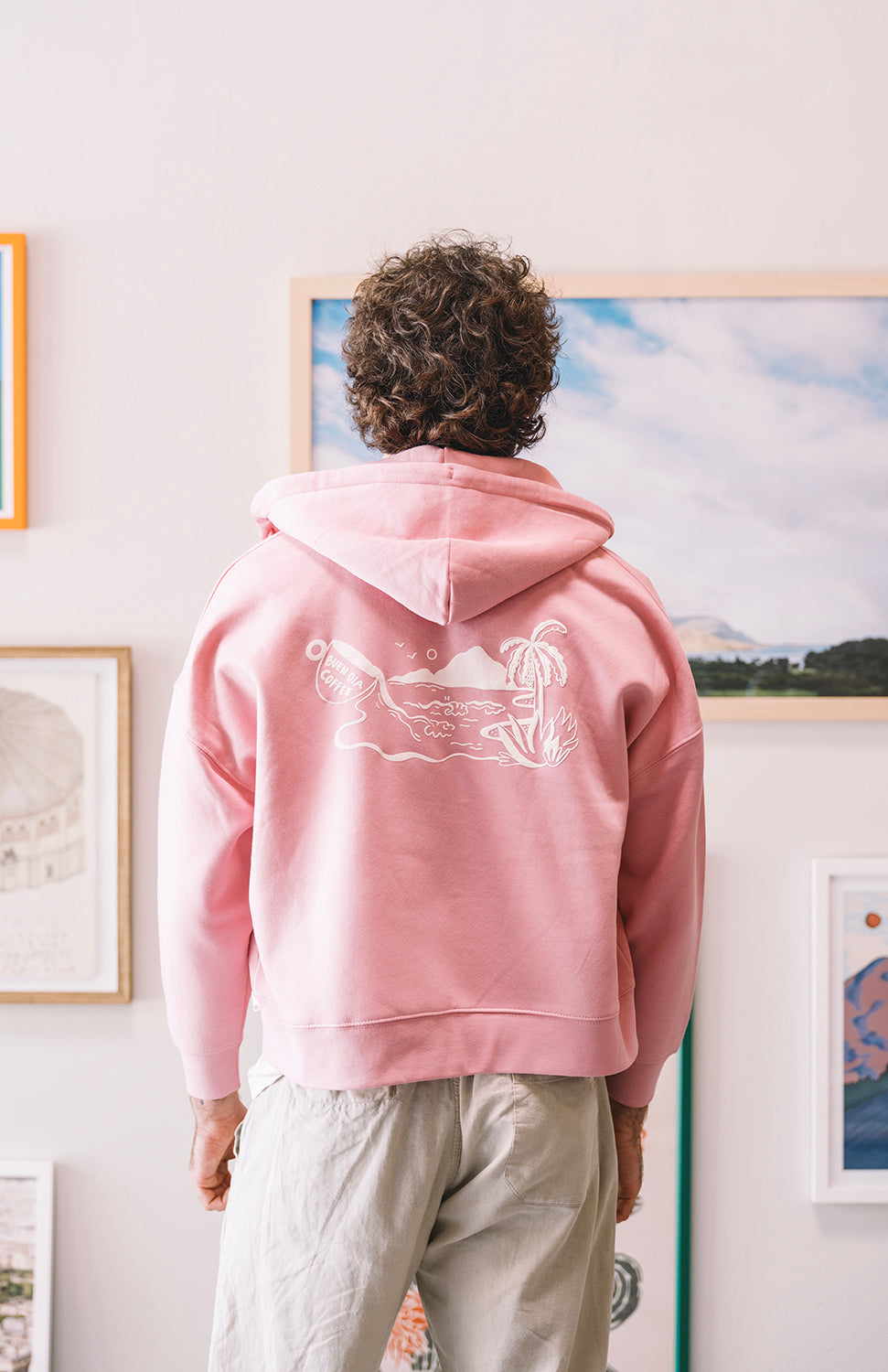 Man with a pink sweater with art wall