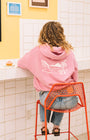 Woman sitting in a coffee shop with a pink hoodie in san luis obispo