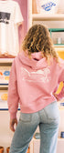 Woman wearing a pink sweatshirt with a zip in buen dia coffee 
