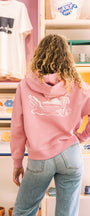 Woman wearing a pink sweatshirt with a zip in buen dia coffee 