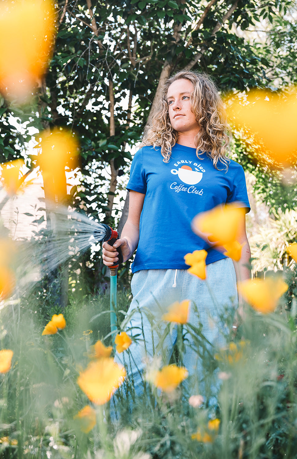 Woman gardening wearing a blue shirt in the sun in san luis obispo