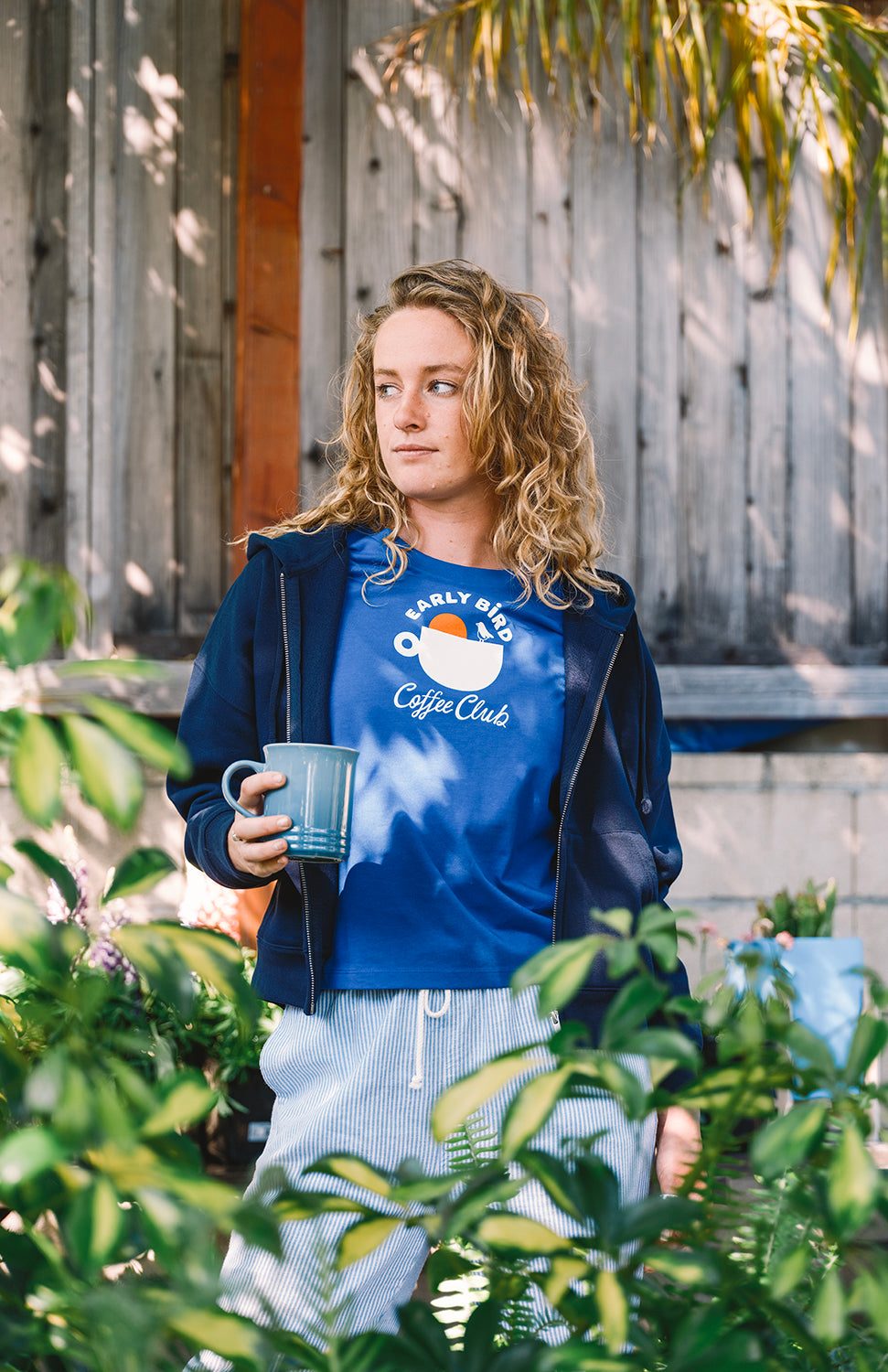 Blue t shirt for women early bird coffee club with a navy blue sweater Buen dia coffee